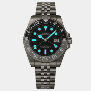 Lumed view of Seiko Bruce Wayne GMT automatic mod watch with black and gray bezel and jubilee bracelet