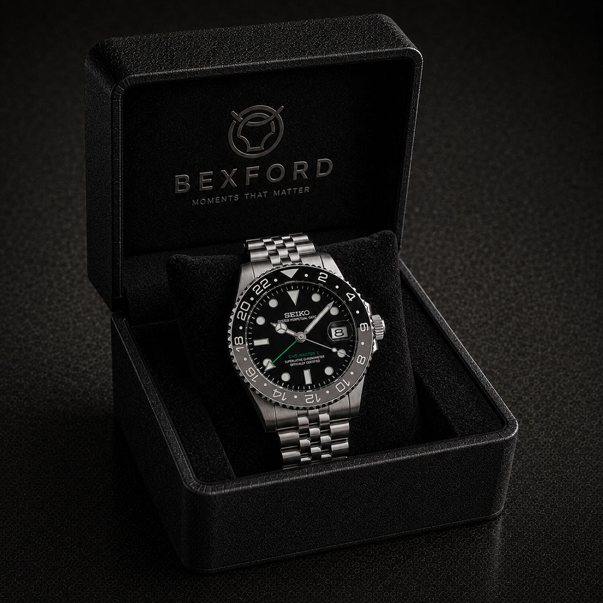 A Bexford stainless steel watch with a black dial and bezel, presented inside its black branded Bexford gift box on a dark background.