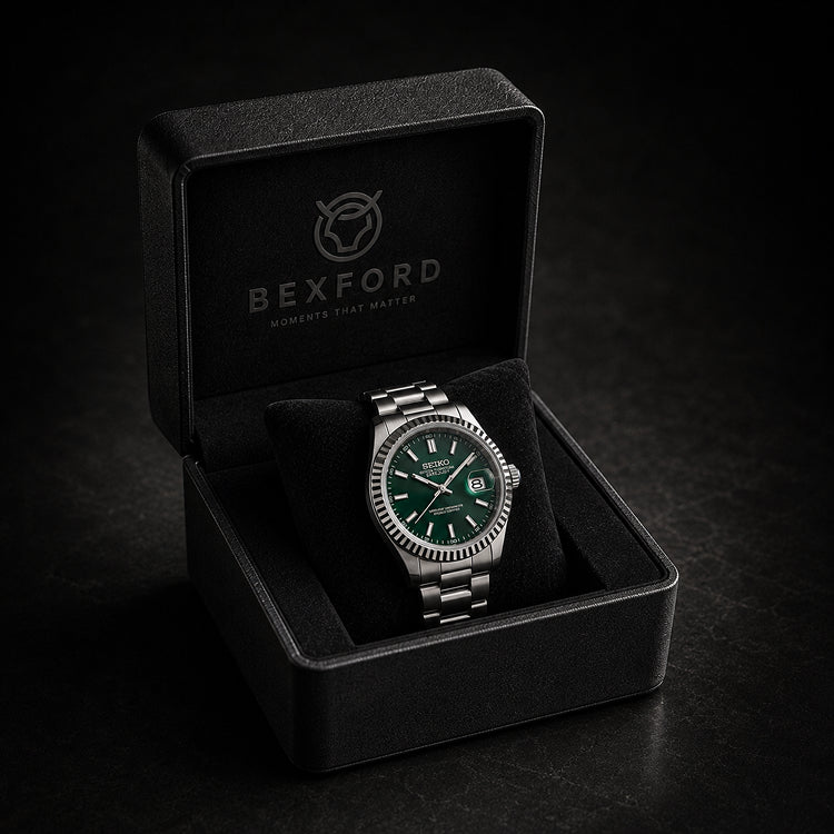 A Bexford wristwatch with a silver-tone metal bracelet and green dial, displayed inside an open black presentation box on a dark background.