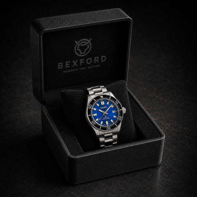 A Bexford stainless steel wristwatch with a vibrant blue dial and black bezel, presented inside its open black branded gift box on a dark textured background.